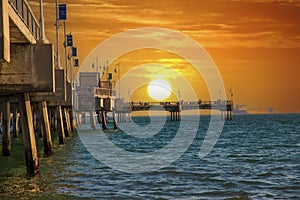 A gorgeous summer landscape at the Belmont Veterans Memorial Pier with blue ocean water and waves rolling into the beach