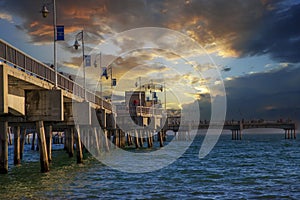 A gorgeous summer landscape at the Belmont Veterans Memorial Pier with blue ocean water and waves rolling into the beach