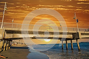 A gorgeous summer landscape at the Belmont Veterans Memorial Pier with blue ocean water and waves rolling into the beach