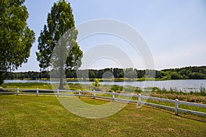 A gorgeous summer landscape at Lake Acworth with rippling blue lake water surrounded by lush green grass and trees