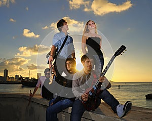 Gorgeous teen musical band posing at sunset