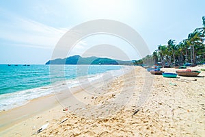 Gorgeous tropical beach turquoise transparent water palm trees, Tu Nham fishing boat and village, Quy Nhon Vietnam central coast