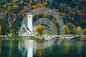 Gorgeous view of colorful autumnal scene of famous Church of St John the Baptist, Bohinj Lake, Ribicev Laz, touristic village in S