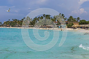 Gorgeous view of hotel private beach. Turquoise ocean warer and white sand beach on green palm trees and blue sky background.