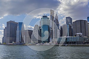 Gorgeous view of Hudson River, Manhattan skyscrapers against blue sky with white clouds. New York.