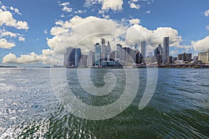 Gorgeous view of Manhattan from river Hudson side. Skyscrapers on blue sky with white clouds background. New York.