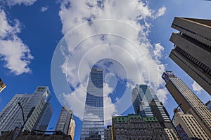 Gorgeous view of skyscrapers of Manhattan against blue sky with white clouds.