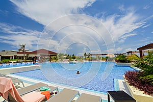 Gorgeous view of swimming pool at Iberostar Playa Pilar resort with people relaxing and enjoying their vacation time on sunny beau