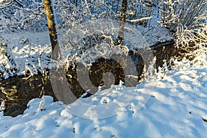 Gorgeous view of winter nature landscape.. Stream in winter forest. Beautiful nature landscape. Trees reflection on water.