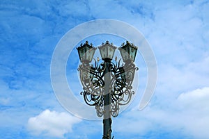 Gorgeous vintage style wrought iron streetlamp against blue sky