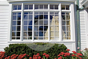 Gorgeous wedding dress hanging from picture window of home