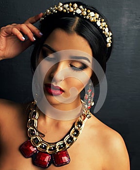 Gorgeous woman with dark hair and bright makeup with luxurious bijou