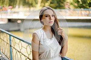 Gorgeous woman with dark hair in elegant white dress