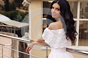 Gorgeous woman with dark hair in elegant white dress