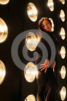 Gorgeous woman demonstrating body shapes in spot lights background.