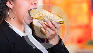 Gorgeous woman eating a delicious humita, traditional andean food concept photo