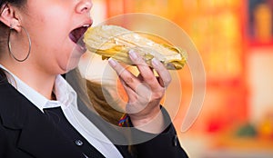 Gorgeous woman eating a delicious humita, traditional andean food concept photo