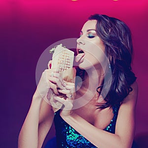 Gorgeous woman eating kebab in night club