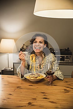 Gorgeous woman eating a plate of Tagliatelle al Ragu Bolognese in a cozy dining room