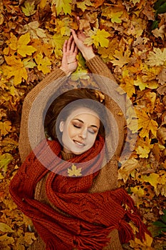 Gorgeous woman in fallen autumn leaves portrait