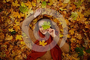 Gorgeous woman in fallen autumn leaves portrait