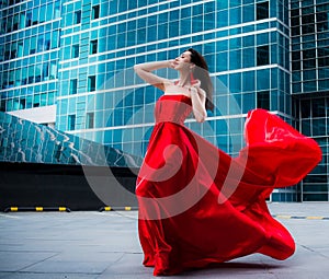Gorgeous woman in red fluttered dress. Freedom concept. Fashion