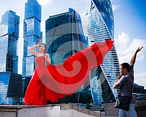 Gorgeous woman in red fluttered dress. Freedom concept. Men admiration