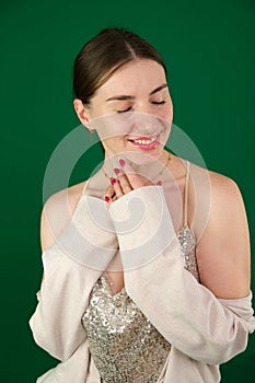 Beautiful young girl in golden dress gorgeous woman in a silver shiny dress on a green background chromakey sexuality photo