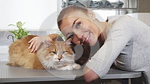 Gorgeous woman smiling posing with her cat at the vet office