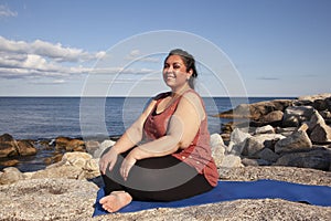 Gorgeous woman smiling on a yoga mat outside