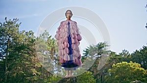 Gorgeous woman standing stone at picturesque sunny forest. Fairy girl posing