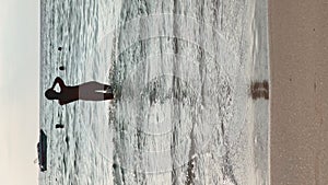 Gorgeous woman in swimsuit is running along sea water waves on sandy beach at sunset, Female tourist on travel vacation