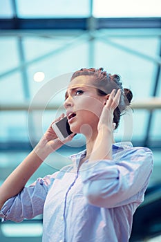 Gorgeous woman talking on mobile phone at airport