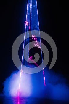 Gorgeous woman under colorful illumination, laser light, neon smoke club.