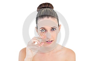 Gorgeous woman using eyelash curler