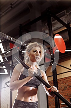 Gorgeous woman is using the sledgehammer during training