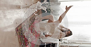 Gorgeous woman wearing stylish vintage bridal dress on chair, posing at home in vintage interior