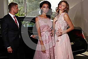 Gorgeous women wear luxurious dress,posing beside black car