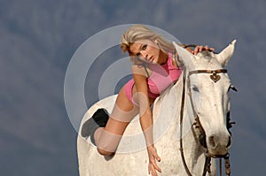 Gorgeous young blonde girl on the horse