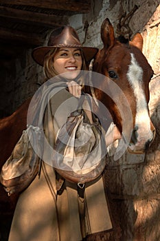 Gorgeous young cowgirl with a horse