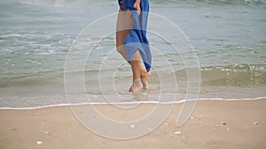 Gorgeous young girl with a beautiful figure posing and walks along the seashore