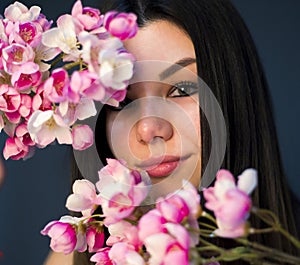 Gorgeous young girl with colorful flowers, studio portrait