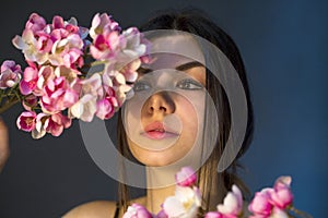 Gorgeous young girl with colorful flowers, studio portrait