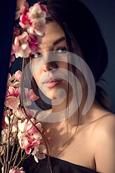 Gorgeous young girl with colorful flowers, studio portrait