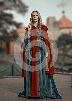 Gorgeous young princess in the medieval dress with red cape