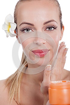 Gorgeous young woman applying face cream