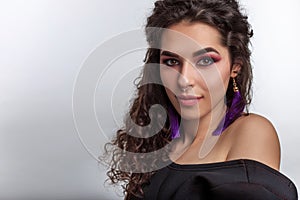 Gorgeous young woman with braun glossy skin curly hair and professional make up