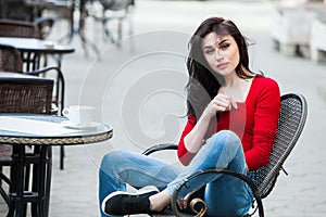 Gorgeous young woman with cup of coffee in city street. Coffee break. Stylish hipster girl drinking coffee in street.