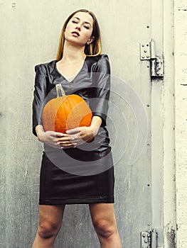 Gorgeous young woman holding pumpkin for Halloween