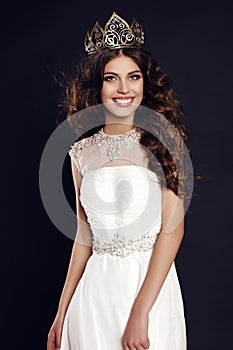 Gorgeous young woman with luxurious hair wearing crown of beauty contest